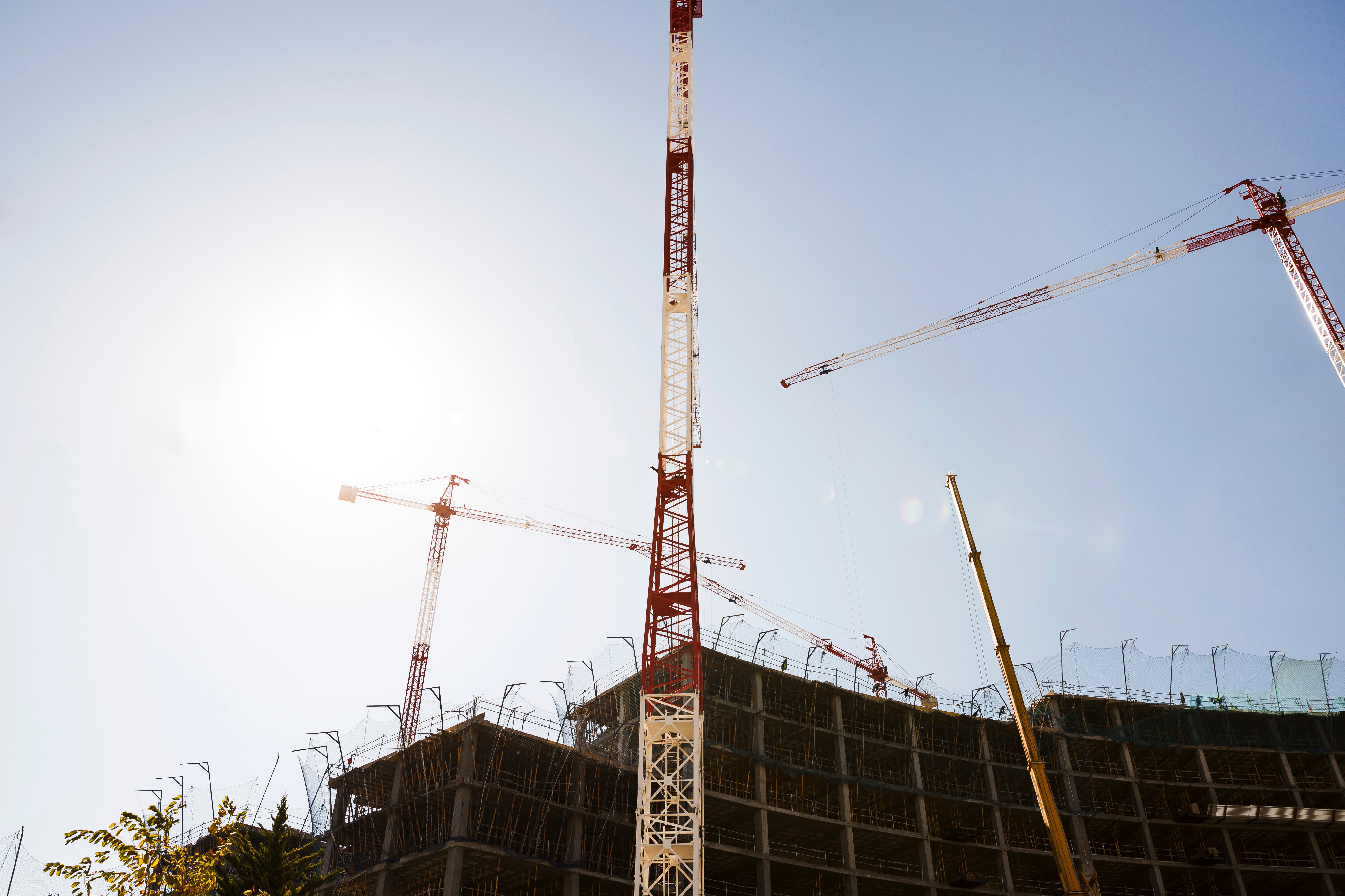 silhouette-buildings-construction-against-blue-sky-sunlight